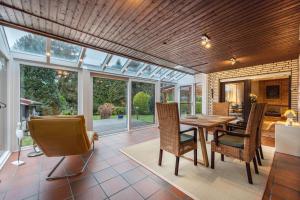 a conservatory with a dining room with a table and chairs at Ferienhaus Timm in Meldorf