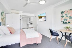 un dormitorio con una cama y una mesa en Cairns Central Studio, en Cairns