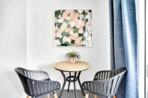 una mesa y 2 sillas en una habitación con una foto en Cairns Central Studio, en Cairns 2 fotos más