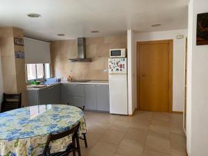 a kitchen with a table and a white refrigerator at Estación 1 in Murcia