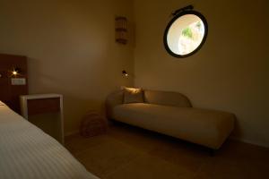 a bedroom with a couch and a round window at JATU Retreat in San Costantino +70 photos
