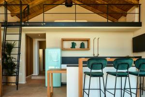 a kitchen with a blue refrigerator and green stools at JATU Retreat in San Costantino