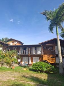 ein Gebäude mit einer Palme davor in der Unterkunft Pousada VistaCalma in Praia do Rosa