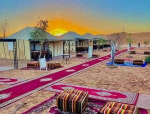 a building in the middle of a desert with luggage at Sunshine luxury tent in Merzouga
