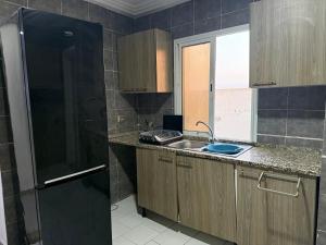 a kitchen with a sink and a refrigerator at Excellent appartement tunis in Tunis