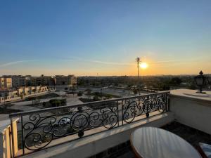 a balcony with a view of a city at sunset at The Grand Penthouse in Cairo