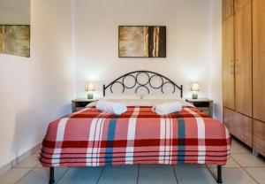 una camera con un letto con una coperta rossa e bianca di Crystal Cherry Apartment a Preveza
