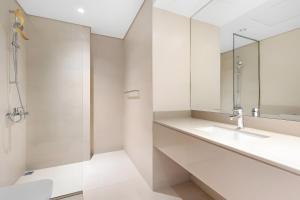 un bagno bianco con lavandino e specchio di Canal View 1BR at Yas Island a Yas Island