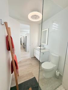 a bathroom with a toilet and a glass shower door at Villa España in Koolbaai