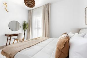una camera da letto bianca con un letto e una scrivania di Canal View 1BR at Yas Island a Yas Island