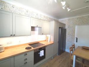 a kitchen with white cabinets and a stove top oven at bayviewapartment in Oban