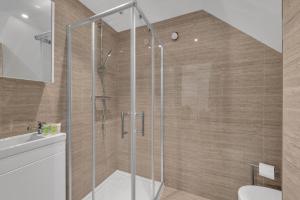 a bathroom with a shower with a toilet and a sink at Micro Chic, Tiny Studio with Functional Desk in Hanwell