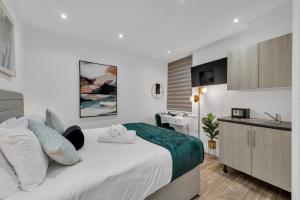a bedroom with a bed and a desk and a sink at Micro Chic, Tiny Studio with Functional Desk in Hanwell