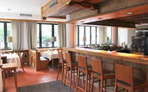 a restaurant with a bar with tables and chairs at Hotel Erzgiesserei Europe in Munich