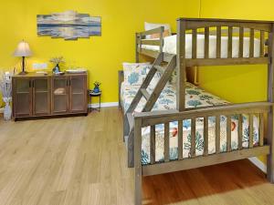 1 dormitorio con paredes amarillas y 1 litera en Seawall Celebration - Manor, en Galveston