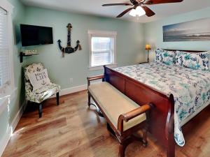 1 dormitorio con 1 cama, ventilador y silla en Seawall Celebration - Manor, en Galveston 47 fotos más