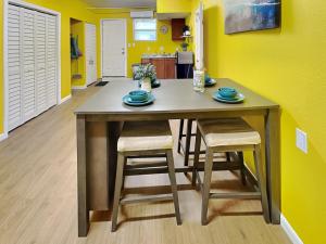 mesa de comedor con 2 sillas y pared amarilla en Seawall Celebration - Manor, en Galveston
