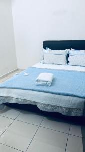 a bed with blue sheets and white pillows on it at Homestay Mdm Mai 2 in Masjid Tanah