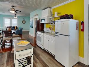 cocina con nevera blanca y comedor en Seawall Celebration - Up, en Galveston