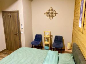 a bedroom with two blue chairs and a bed at Mavrovo_apt4 in Mavrovo