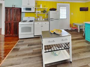 cocina con electrodomésticos blancos y paredes amarillas en Seawall Celebration - Up, en Galveston