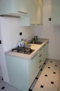 uma cozinha branca com um fogão e um lavatório em Casa Auxilium em Rapallo