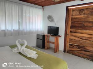a bedroom with a wooden door and a television at Hotel Marshell Meals inclusive in Chimo