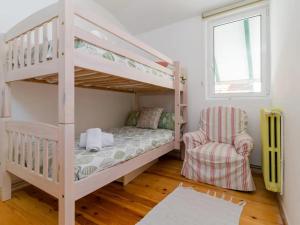 une chambre avec un lit superposé et une chaise dans l'établissement Casa Anzano, à Santander