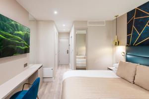 a hotel room with a bed and a blue chair at NOX Belsize Park in London