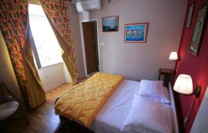 ein kleines Schlafzimmer mit einem Bett und einem Fenster in der Unterkunft Apartments Tedeschi in Korčula