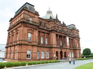 a large brick building with people standing outside of it at Glasgow city Charlotte service Aparments in Glasgow