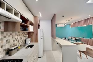 cocina con electrodomésticos blancos y pared azul en iFlat Metropoliran Barcelona MB205B Jardim Goiás, en Goiânia