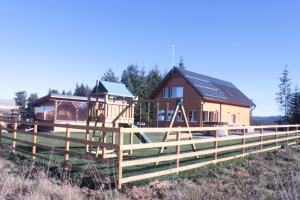 une clôture en bois devant une maison dans l'établissement Vanilla Mountain Resort, à Bălceşti 13 autres photos