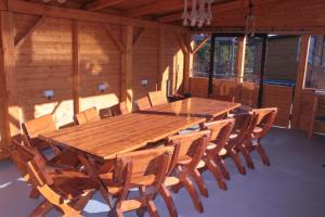 une grande table en bois et des chaises dans une pièce dans l'établissement Vanilla Mountain Resort, à Bălceşti
