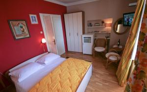 a bedroom with a bed and a red wall at Apartments Tedeschi in Korčula