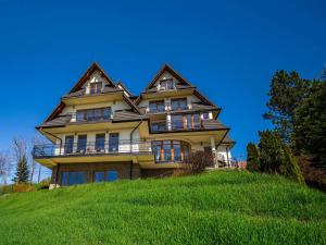 a large house on top of a grassy hill at Gabrysia in Bukowina Tatrzańska