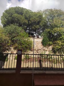 Un balcón con una valla y árboles al fondo. en pueblo, en Benalmádena