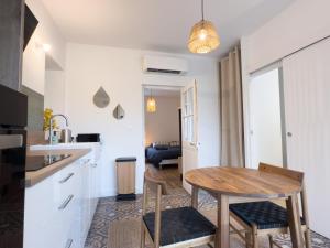 a kitchen and dining room with a wooden table and chairs at Evasion T2 avec terrasse in Saint-Didier-sur-Chalaronne