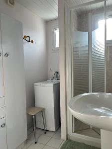 Un baño con lavabo y lavadora. en 1 - Maison de pêcheur Pré vert, en Pornic