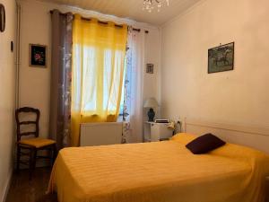 Un dormitorio con una cama amarilla y una ventana. en 1 - Maison de pêcheur Pré vert, en Pornic