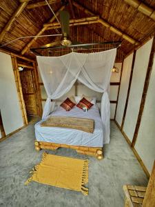 a bedroom with a bed with a mosquito net at Izotal Bioluxury Hotel in Taminango