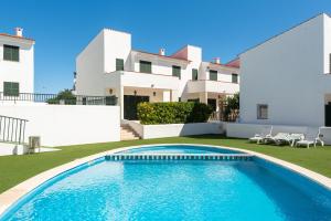 a villa with a swimming pool in front of a house at 3 Bedroom Villa, 300m to Arenal d'en Castell Beach in Punta Grossa