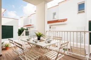 a balcony with a white table and chairs at 3 Bedroom Villa, 300m to Arenal d'en Castell Beach in Punta Grossa