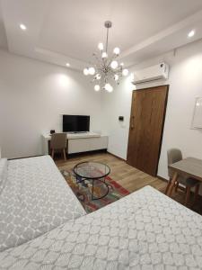 Un dormitorio con una cama, una mesa y un televisor. en Coquet appartement avec piscine à 10min de l'aéroport Tunis - family only, en La Soukra 26 fotos más