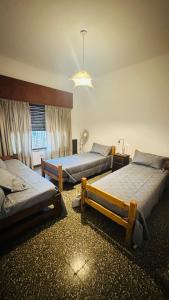 米娜克拉韦罗Lomablanca的一间房间里有三张床的卧室