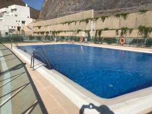 Una gran piscina azul frente a un edificio en El pequeño paraíso, en San Juan de los Terreros