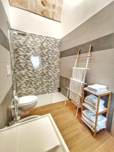 a bathroom with a shower and a toilet and towels at Casa GioNi’ in Monopoli