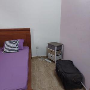 a bedroom with a bed and a night stand at Le séjour fruité in Ouidah