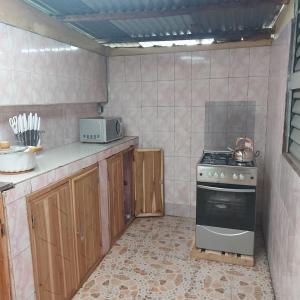 a kitchen with a stove and a microwave in it at Le séjour fruité in Ouidah
