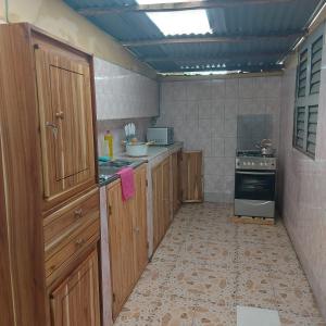 a kitchen with wooden cabinets and a stove at Le séjour fruité in Ouidah